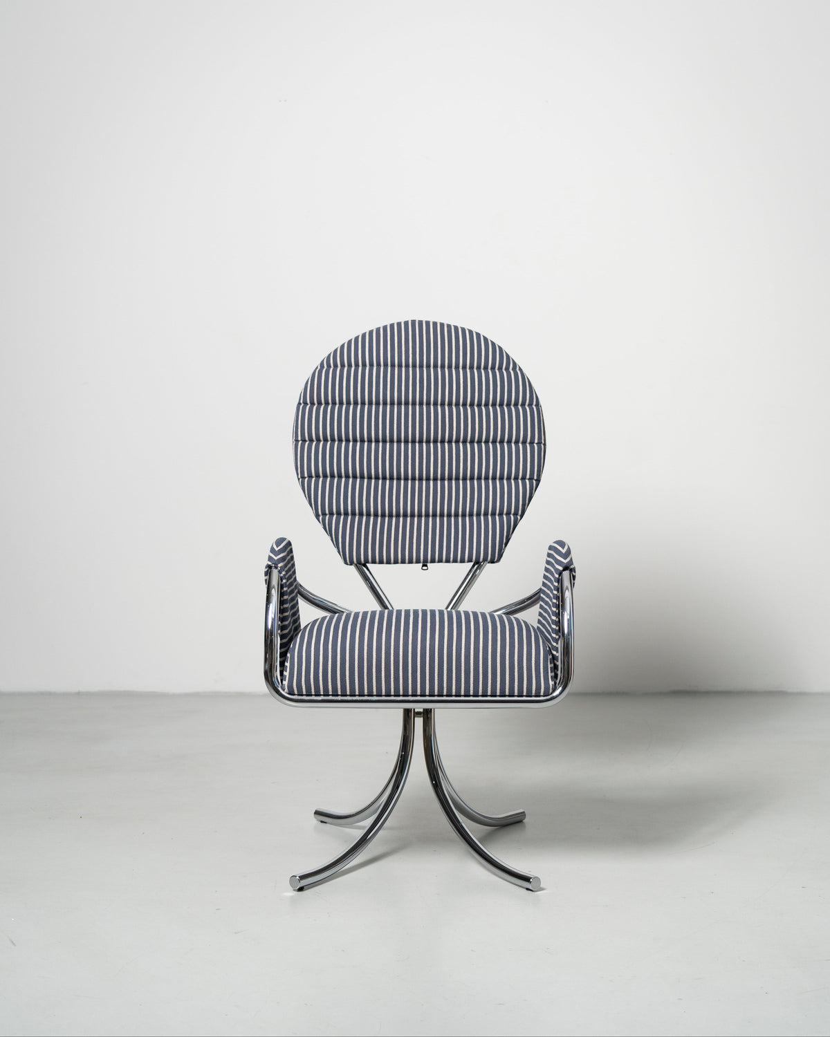 A wool upholstered chair with a chrome-plated steel frame and a rounded backrest, designed in a modernist style.