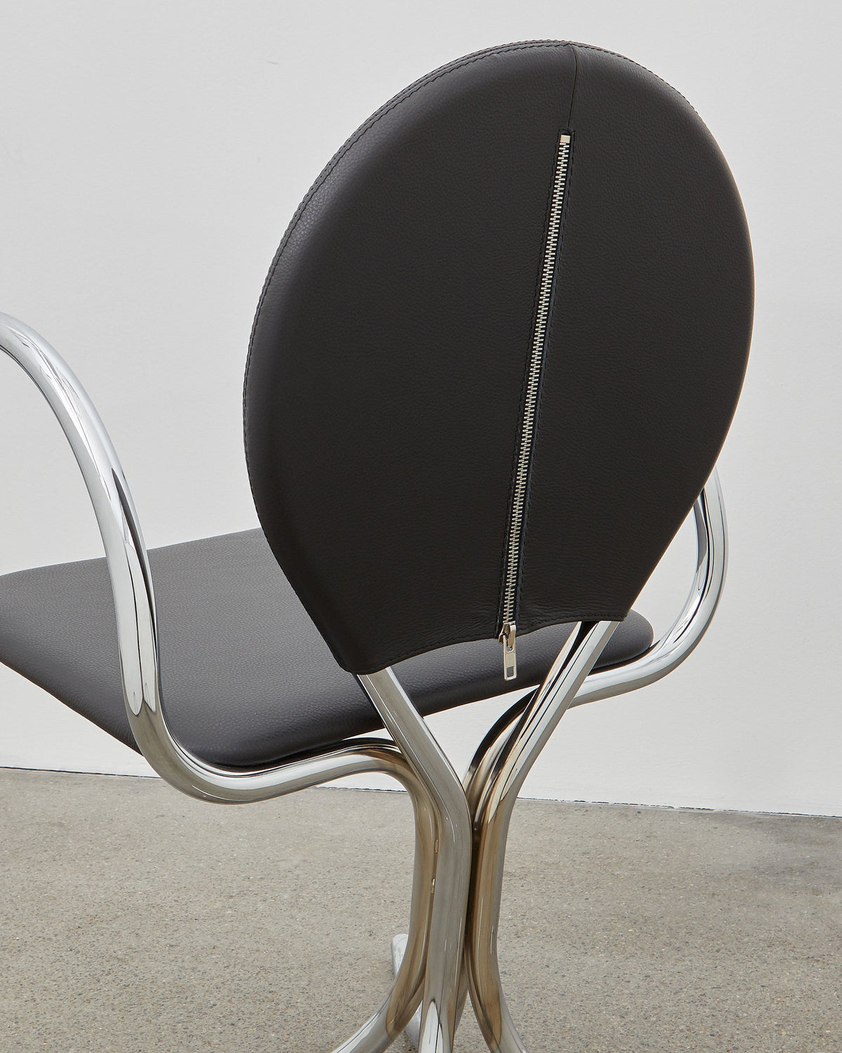 PH Arm Chair by Poul Henningsen, Danish design classic (1932),A armchair with a black cushioned seat and backrest, and chrome steel tube frame.