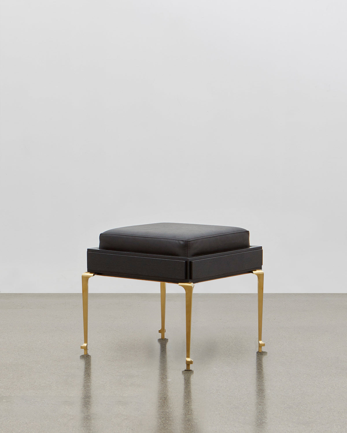 PH Stool by Poul Henningsen, Danish design classic (1920) A black upholstered stool standing on four brass legs