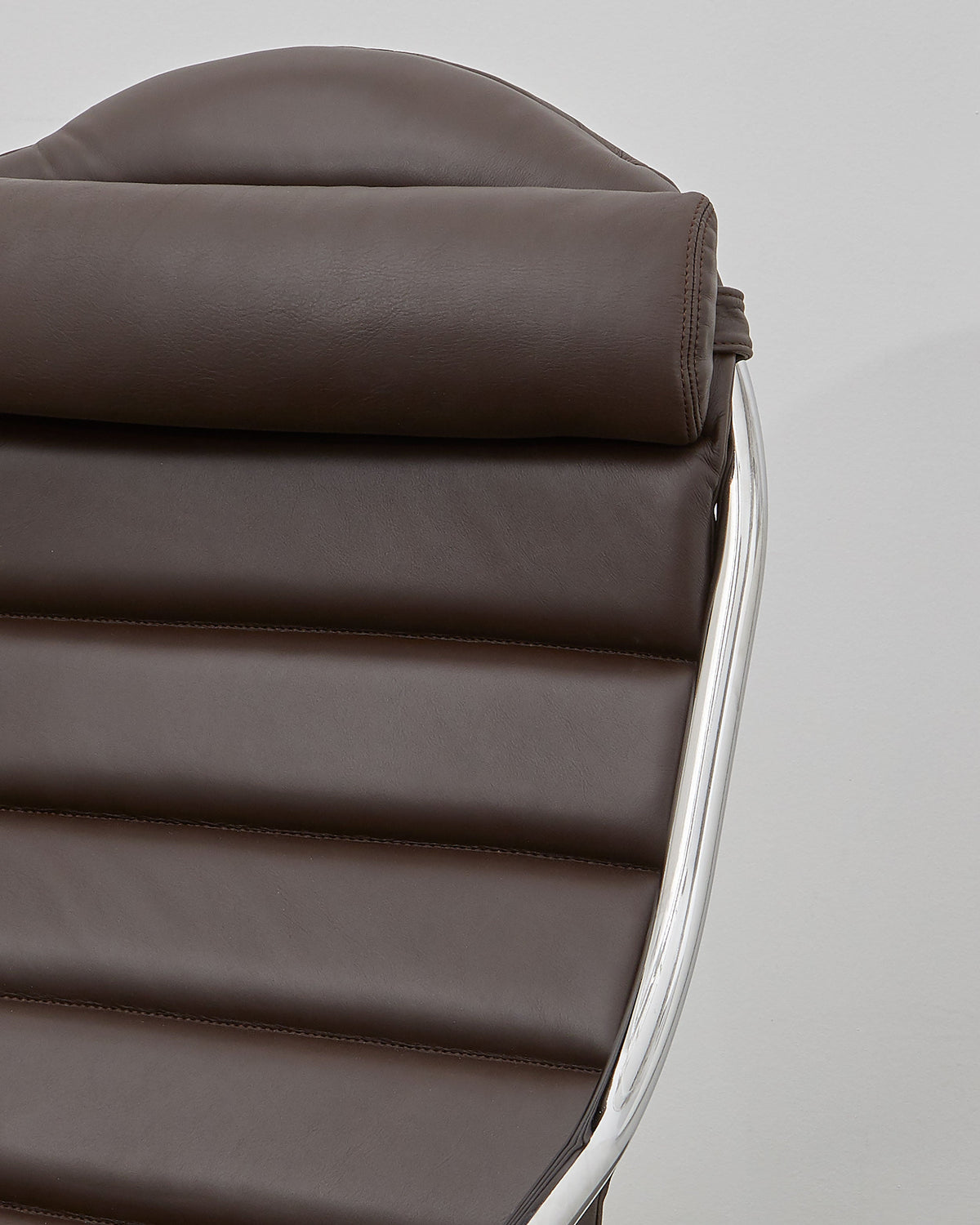 A brown leather upholstered PH lounge chair with a chromed steel tube frame, designed by Poul Henningsen.