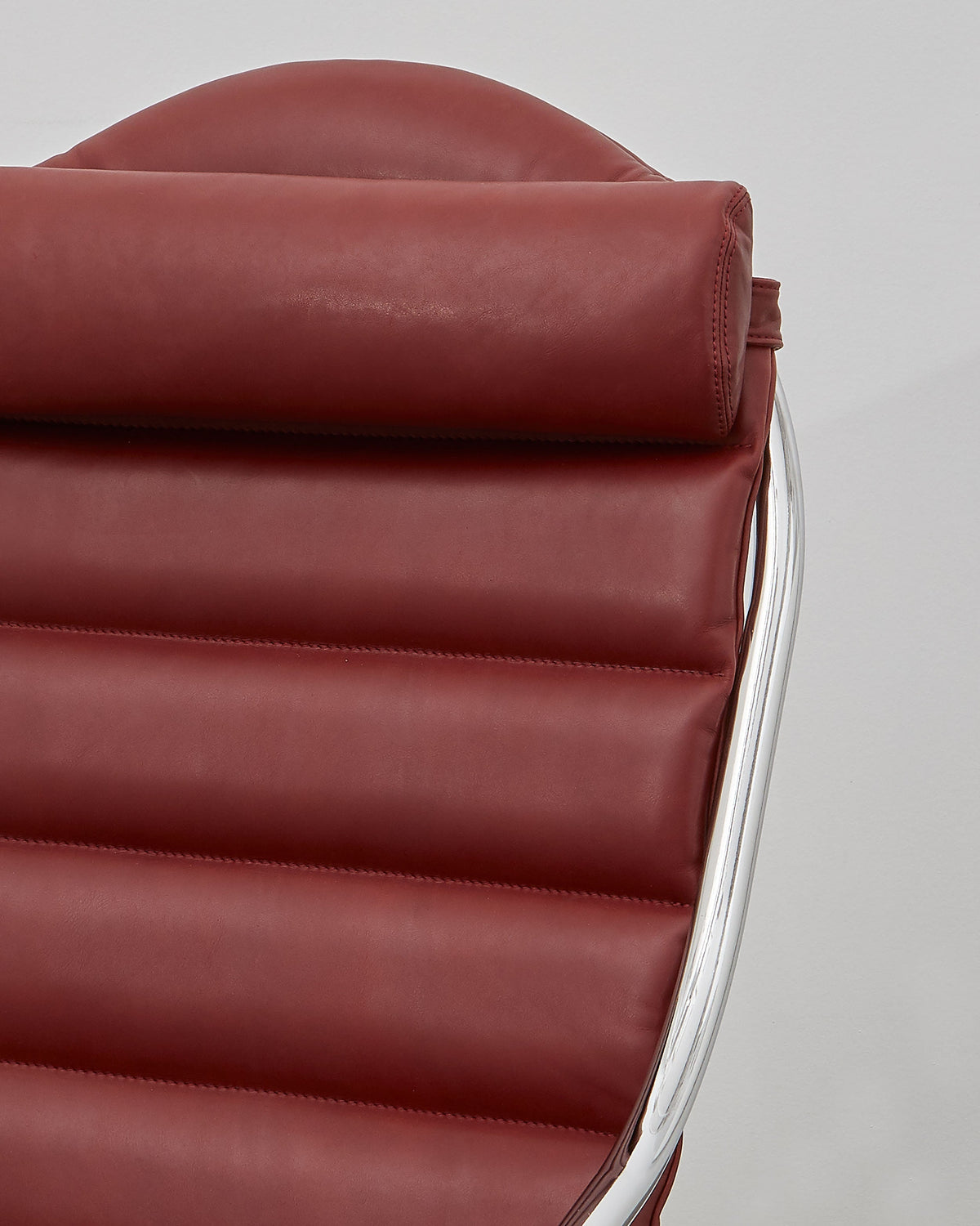 A red leather upholstered PH lounge chair with a chromed steel tube frame, designed by Poul Henningsen.