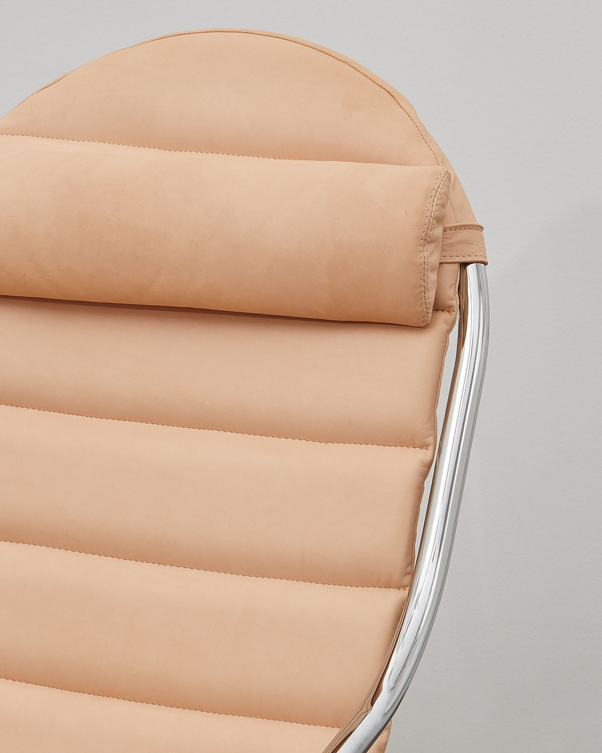 A beige leather upholstered PH lounge chair with a chromed steel tube frame, designed by Poul Henningsen.